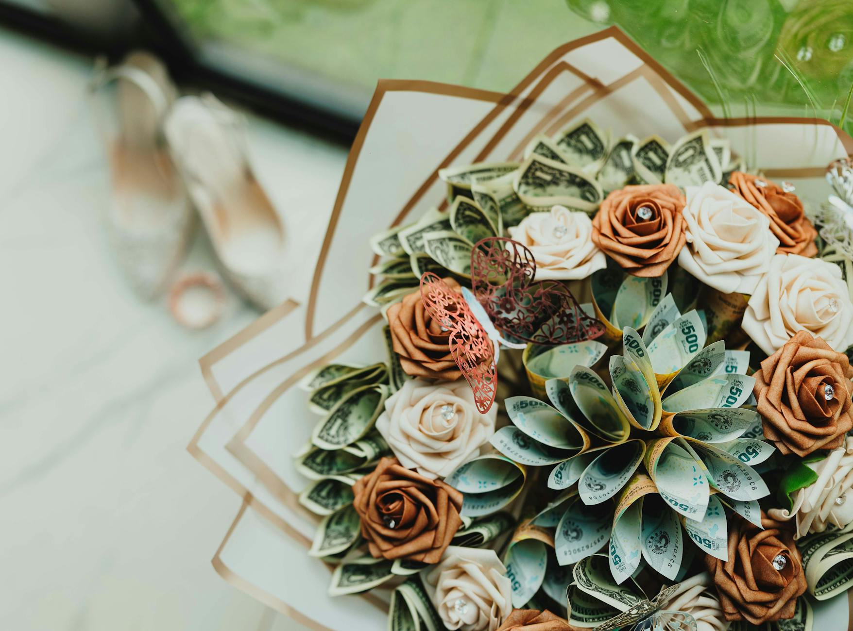 Bukiet papierowych kwiatów z banknotami i ozdobnym motylem