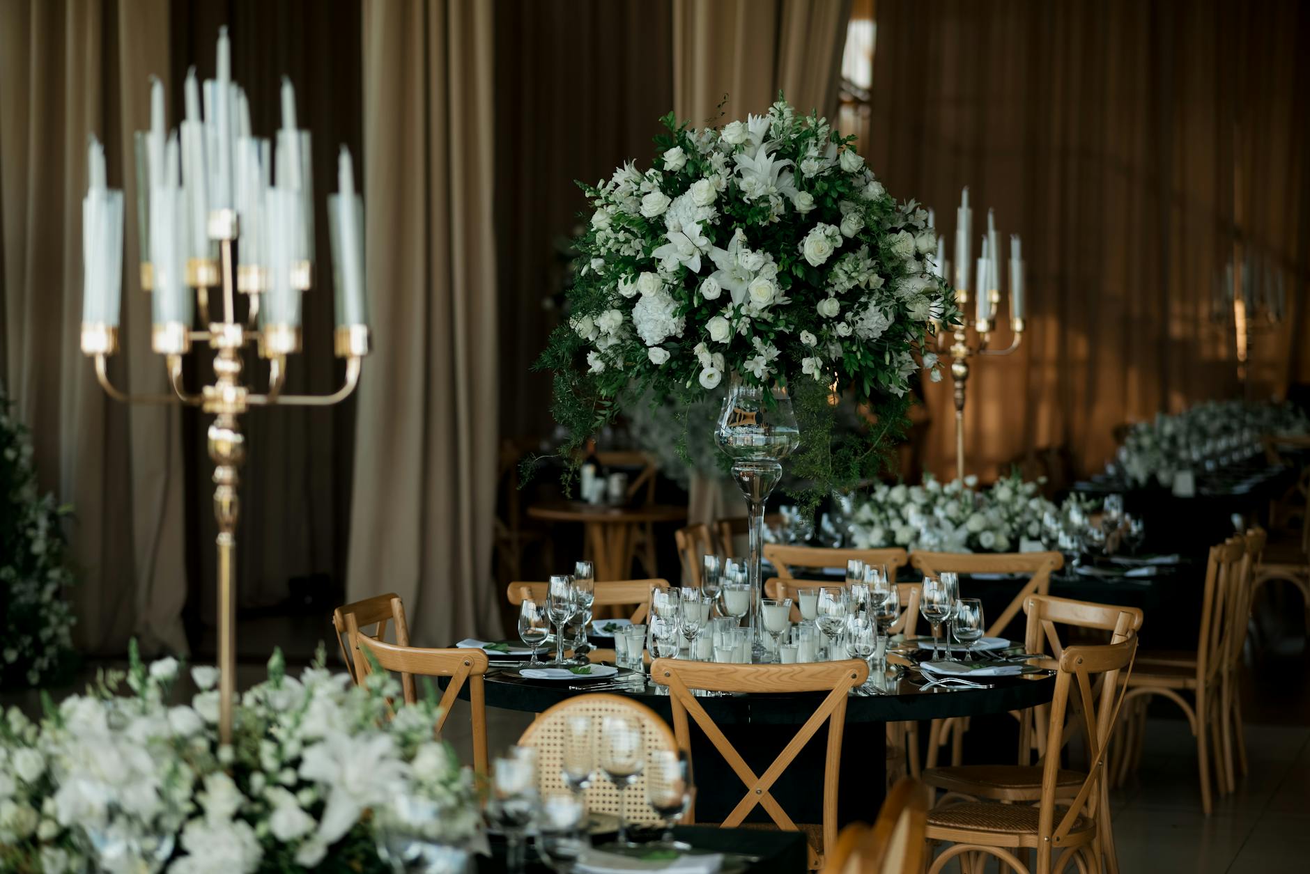 Elegancka sala weselna w dworku z kwiatami i stołami w blasku świec