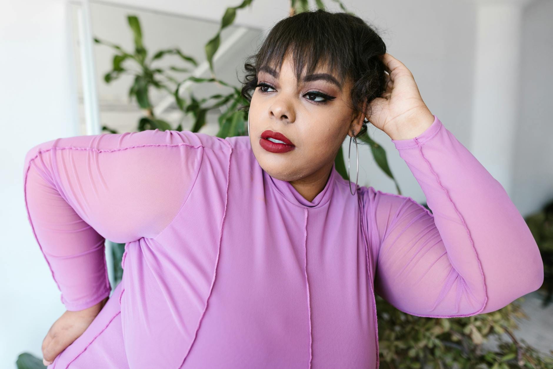 Pewna siebie kobieta plus size w fioletowej stylizacji w pomieszczeniu