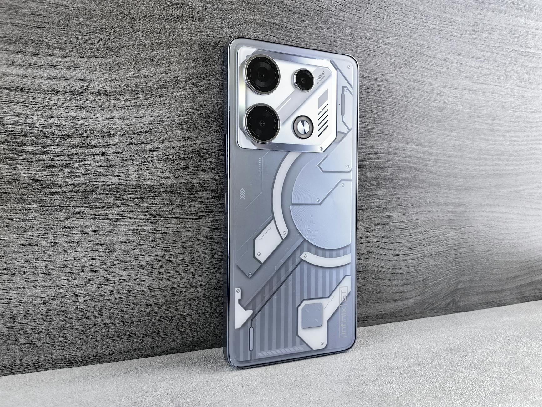 Nowoczesny smartfon o futurystycznym designie leży na drewnianej powierzchni Nowoczesny smartfon o futurystycznym designie leży na drewnianej powierzchni