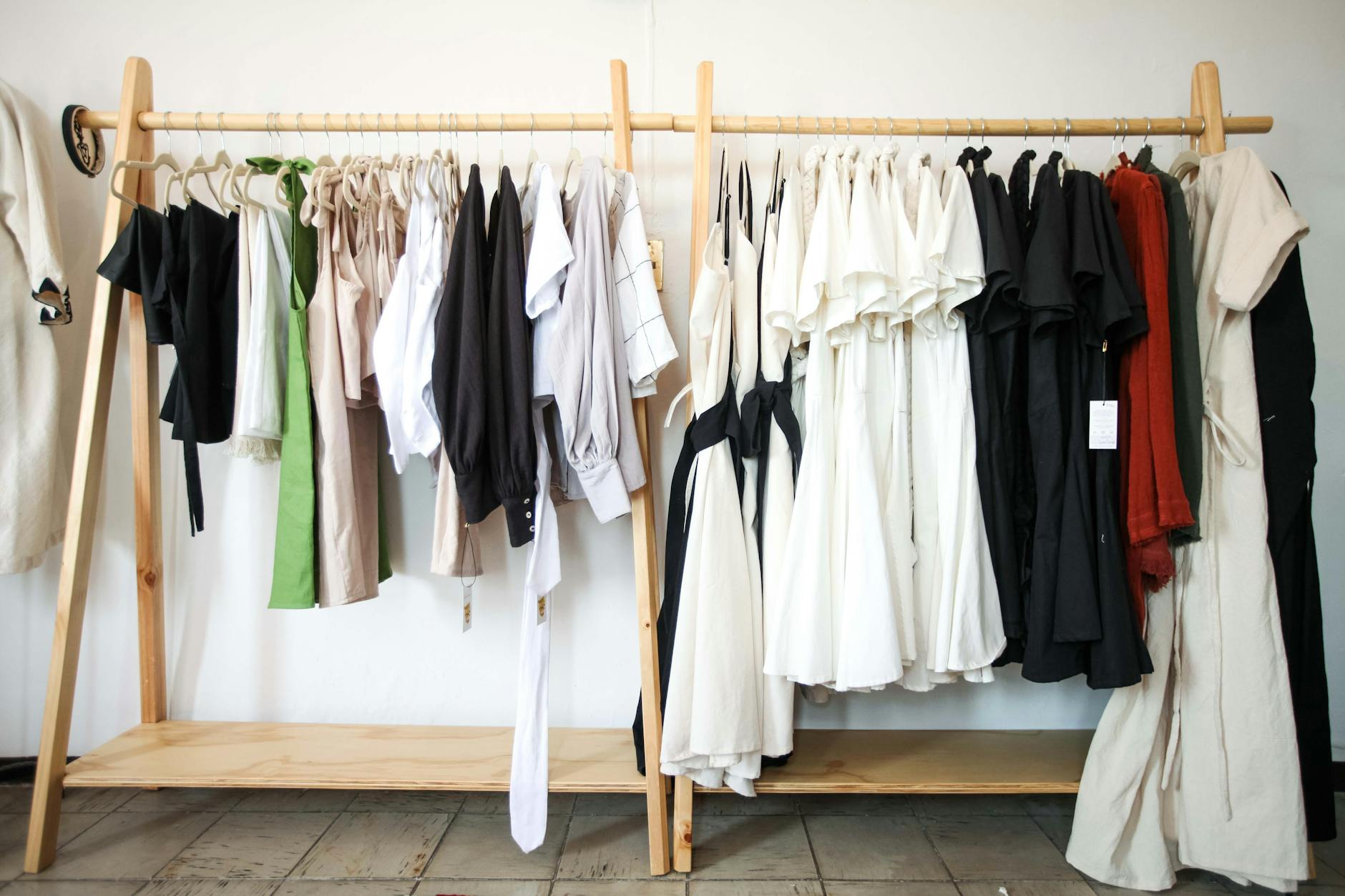 Ubrania w stylu slow fashion wiszące na drewnianym wieszaku