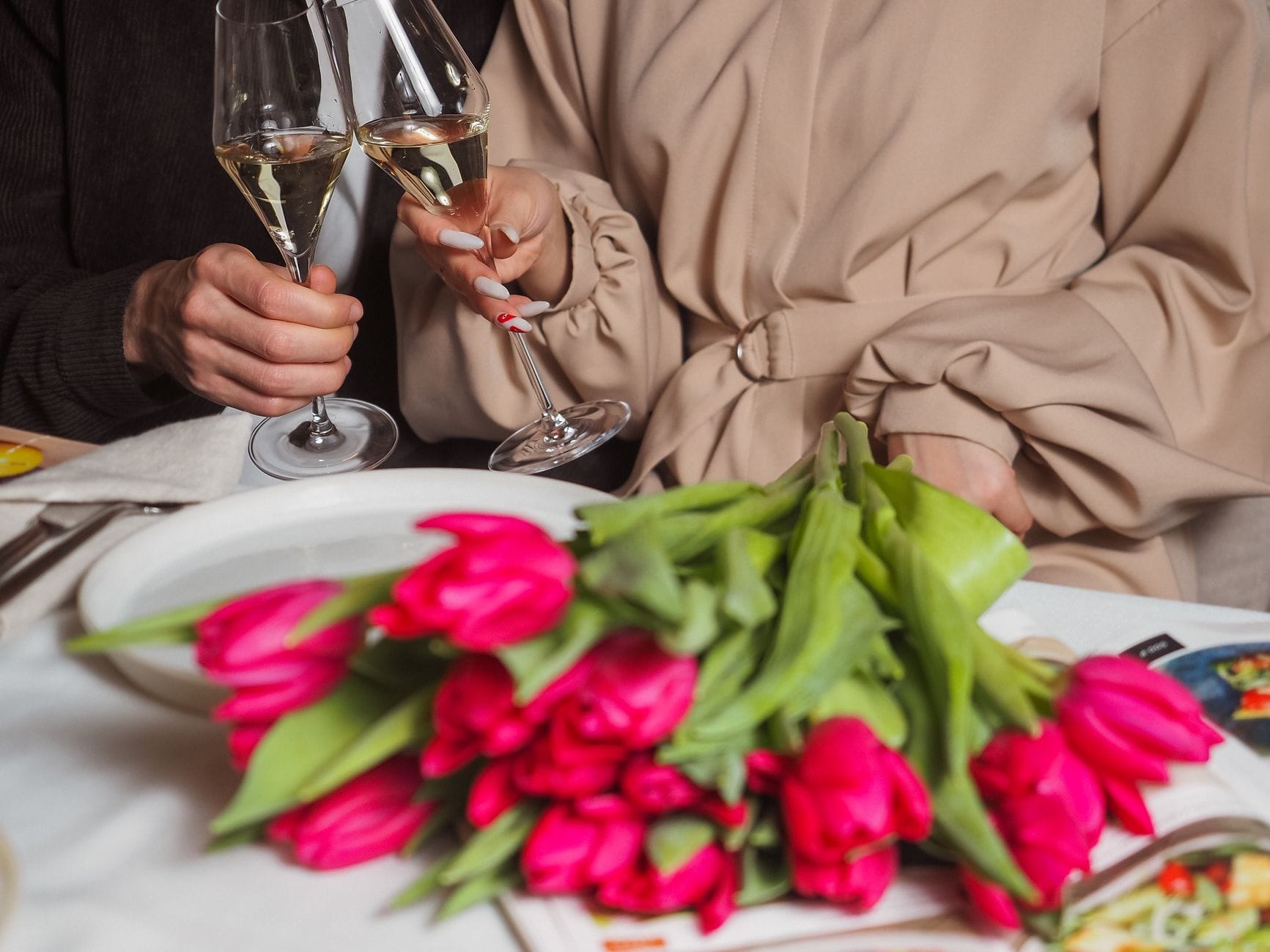 Menu na złote gody: tradycyjne potrawy w odświeżonej, eleganckiej odsłonie Para wznosząca toast szampanem przy elegancko nakrytym stole